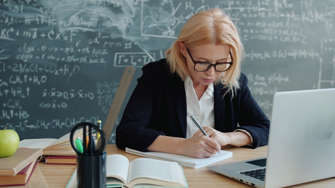 teacher writing at desk