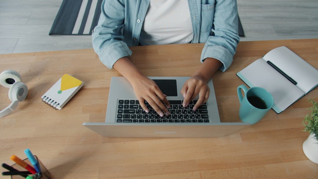 student typing on laptop desk