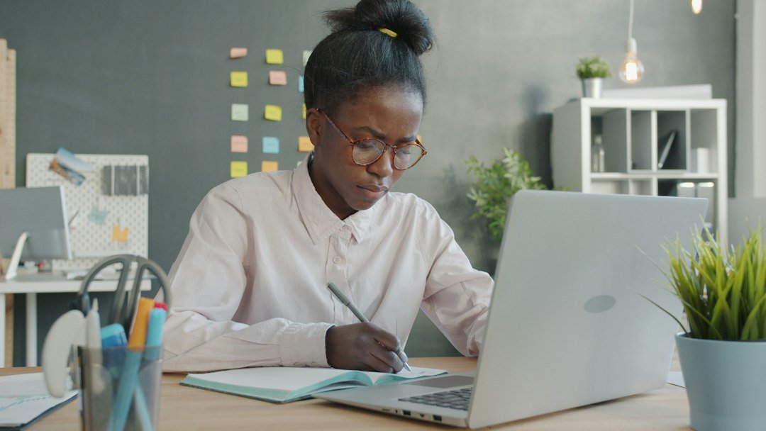 student writing notebook desk